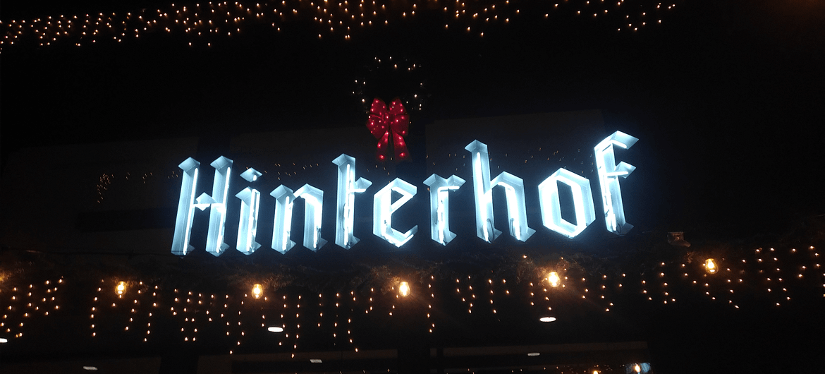 hinterhof sign infront of hinterhof vegan restaurant and beer garden with white lights surrounding it and a wreath above it