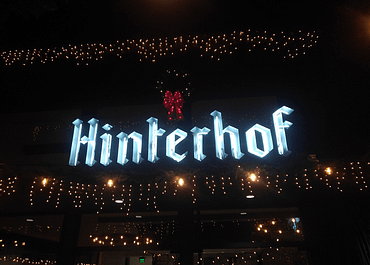 hinterhof sign infront of hinterhof vegan restaurant and beer garden with white lights surrounding it and a wreath above it