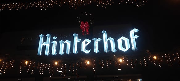 hinterhof sign infront of hinterhof vegan restaurant and beer garden with white lights surrounding it and a wreath above it